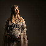 Future maman guidée par sa photographe pendant une séance photo grossesse au studio à Rémilly