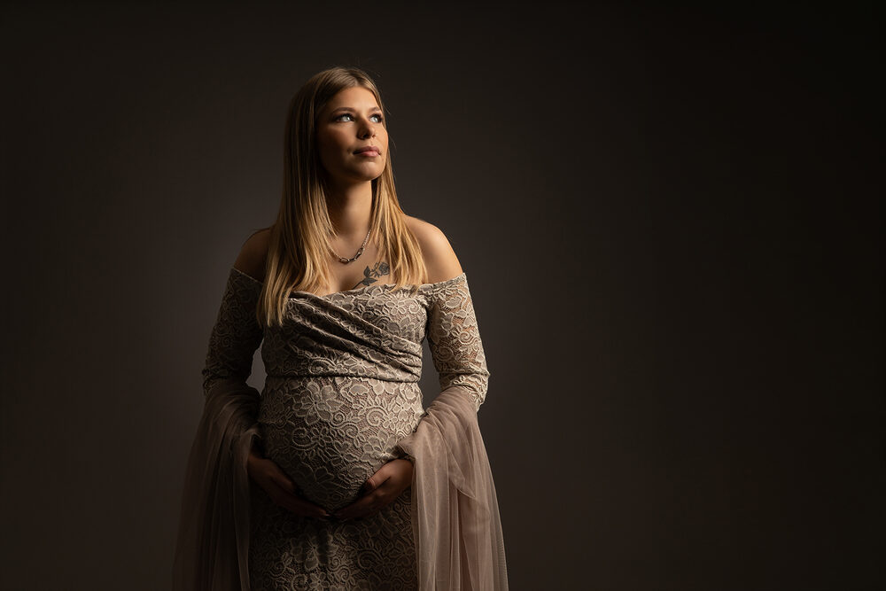 Future maman guidée par sa photographe pendant une séance photo grossesse au studio à Rémilly